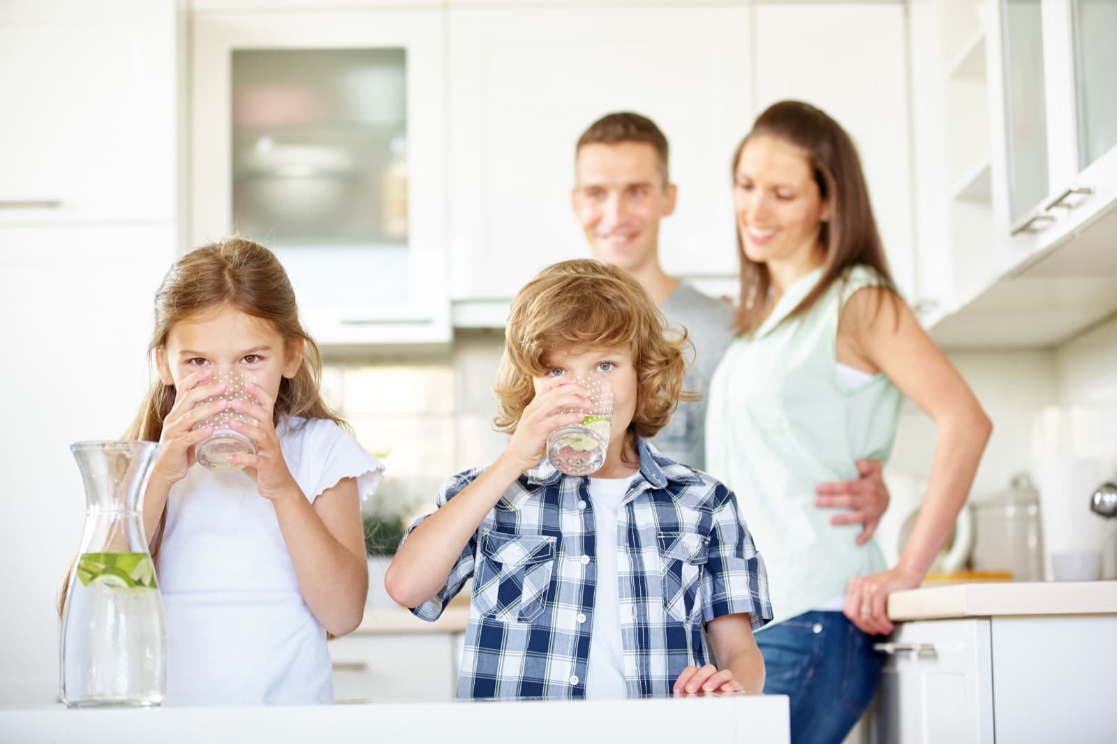 Family drinking clean water in their kitchen