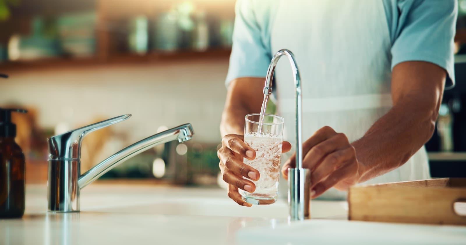 Man filling glass at faucet